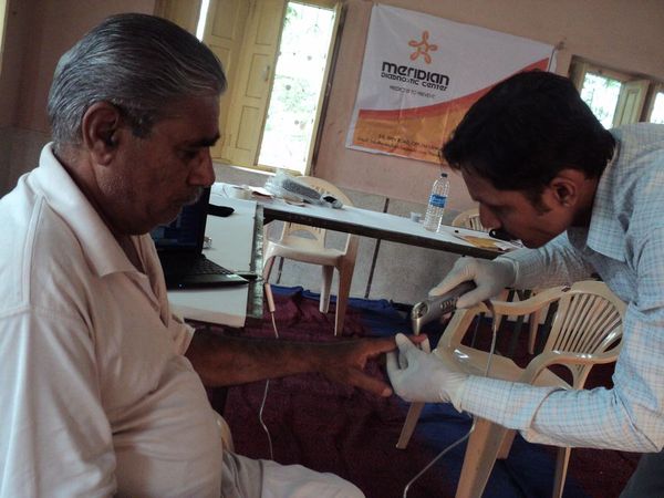 A reading being taken from a visitor’s hand at a Meridian wellness camp